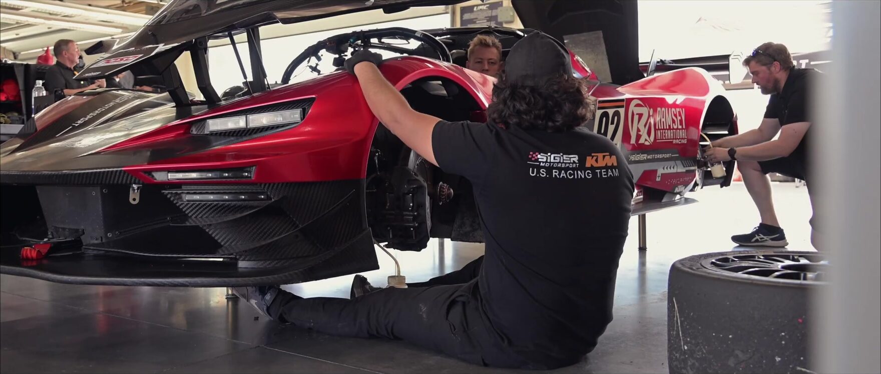 A mechanic working underneath the race car in the garage